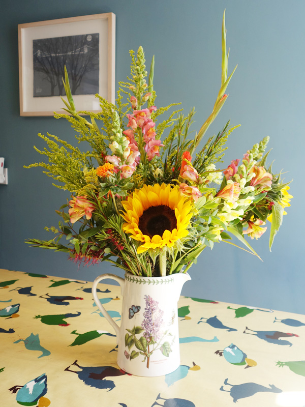 vase of English summer flowers in a blue kitchen